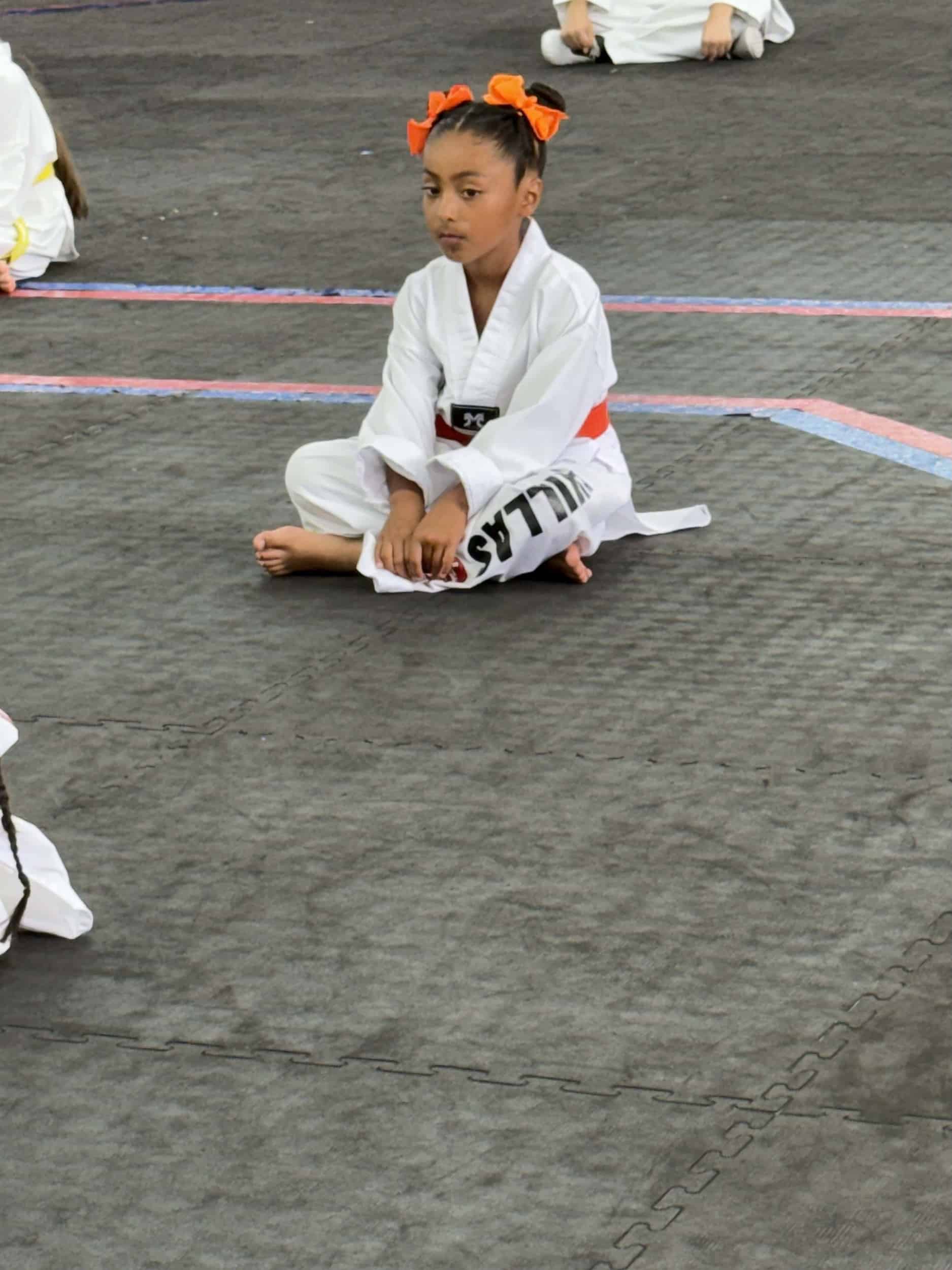 Villa's Taekwondo student sitting on mats during Taekwondo demonstration during kids class